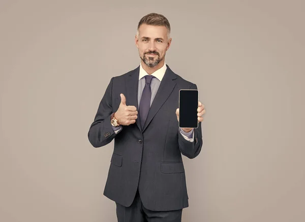 Reifer Mann Influencer Mit Grimmigem Haar Anzug Präsentiert Handy Gerät — Stockfoto