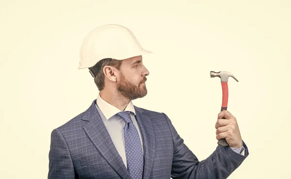 confident businessman man in suit and safety helmet hold hammer isolated on white, safety business.