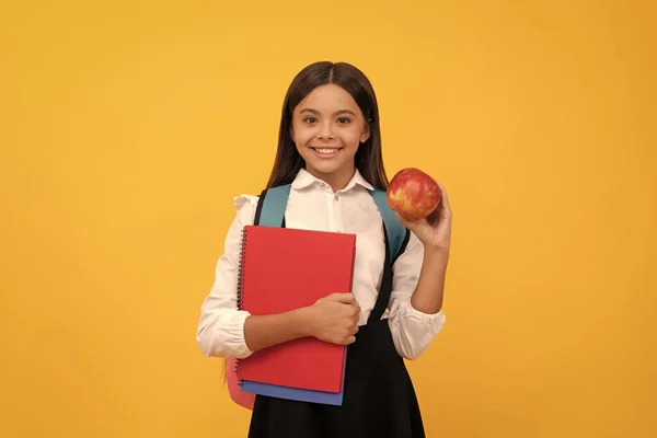 Happy Girl Child Smile Holding Apple Books Yellow Background School — Zdjęcie stockowe