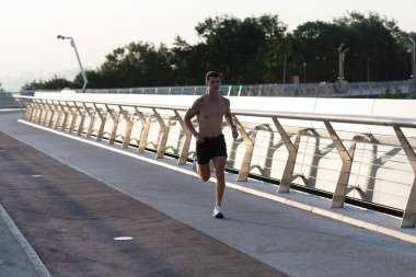 Kaslı gövdesi olan atletik bir koşucu..