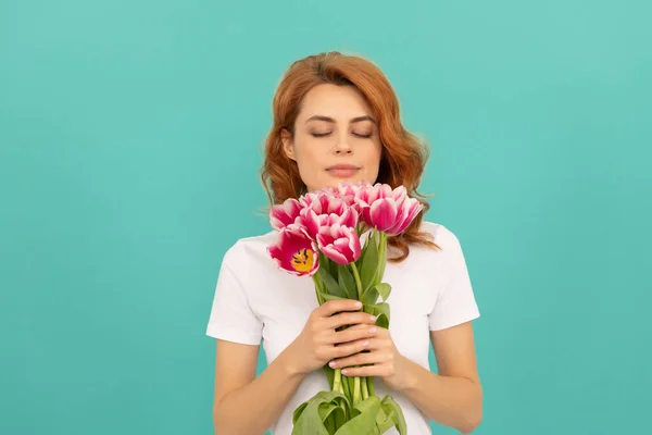 Kız Mavi Arka Planda Lale Çiçeği Kokusu Alıyor — Stok fotoğraf