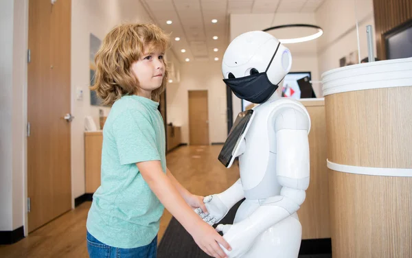 Oğlan robotla yenilikçi teknoloji ve iletişim gibi etkileşim içinde..