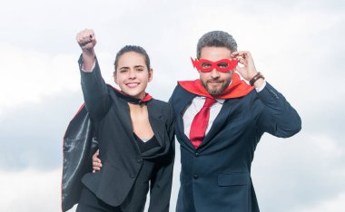 Gökyüzü geçmişinde süper kahraman kıyafeti giymiş mutlu bir çift..