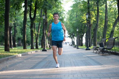 Atletik koşucu spor kıyafetleri içinde koşuyor..