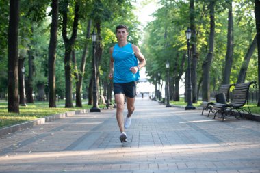 Atletik koşucu spor kıyafetleri içinde koşuyor..