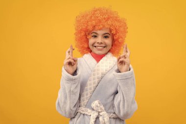 Kıvırcık palyaço peruğu takan komik çocuk. Süslü çocuklar bornoz giyer. Turuncu saçlı, rahat bir uyku tulumu giymiş gülümseyen genç kız. Şans dile. Günaydın. çocukluk mutluluğu. Doğum günü ya da pijama partisi.