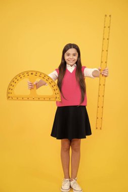 Mutlu kız, matematik ve ölçüm öğrenmek için açıölçer cetvel kullanır..