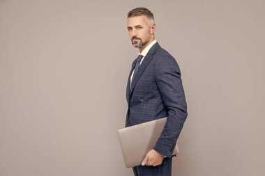 Çevik iş. Profesyonel ağ yöneticisi bilgisayarı tutuyor. Modern kablosuz bilgisayarı olan patron. Takım elbiseli olgun iş adamı. İş başarısı. Bilgisayarlı programcı. Girişimci ya da yönetici.