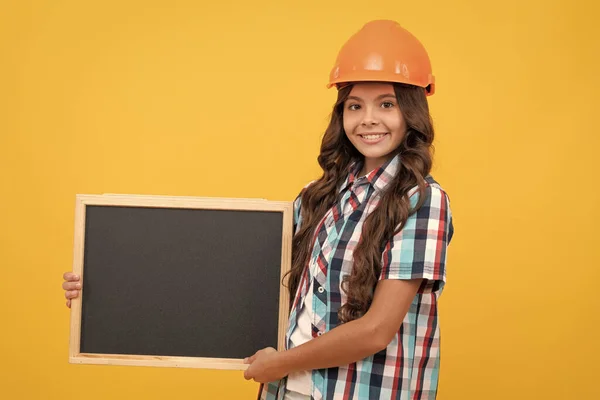 happy workers day. cheerful teen girl laborer hold blackboard. child advertising labor day. back to school. kid presenting novelty information. childhood education. copy space for announcement.