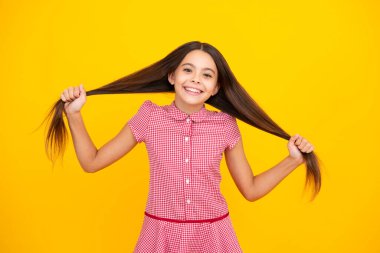 Sarı arka planda çocuk stüdyosu portresi. Çocukluk yaşam tarzı konsepti. Sevimli genç kız yüzü. Yakından.