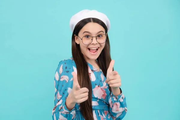 Excited teenager, amazed and cheerful emotions. Happy teenager, positive and smiling emotions. Cheerful teen child posing isolated over yellow background pointing to you