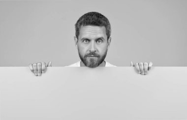 Duyuru. Alışveriş ve indirim. Yenilik bilgisi sunuyorum. Sarı kağıdın arkasındaki erkek. Pazarlama tasarımın için. Reklam için fotokopi alanı olan sakallı adam. erkek reklamcılığı.