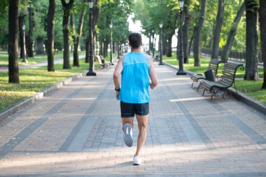 Spor giysileriyle koşan atletik bir adam. arka plan.