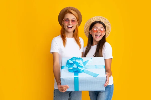 Mothers day. Family, child, holiday and party concept. Smiling mother and daughter with gift box. Cheerful mom and her cute daughter girl with gifts. Parent and child having fun