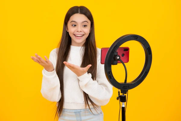 Young blogger recording video for blog. Teen girl speaking in front of camera for vlog. Teenager working as blogger, recording video tutorial for blog
