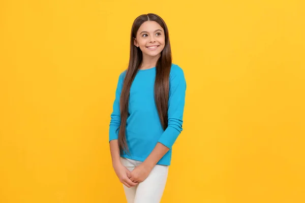 positive child with long hair on yellow background, fashion.