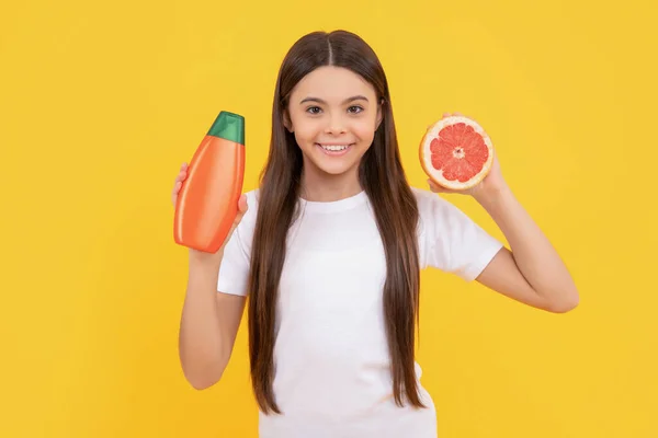 Usmívající Teen Dívka Dlouhé Vlasy Tělové Mléko Grapefruit Žlutém Pozadí — Stock fotografie