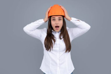 Heyecanlı genç bir kadın inşaat müdürü. Kadın müteahhit portreyi korumalı miğferle izole etmiş. Gri arkaplan