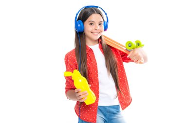 Gençlerin yaşam tarzı, gelişigüzel gençlik kültürü. Kaykay ve kulaklıklı genç kız beyaz izole stüdyo geçmişine sahip. Şık giyinmiş modern havalı bir genç. Mutlu çocuk portresi