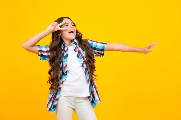 Amazed child with open mouth on yellow background, surprise. Excited expression, cheerful and glad