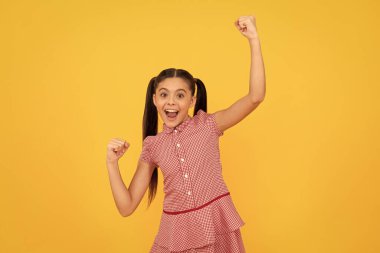 Kazanan gibi hissediyorum. Şanslı kazanan sarı arka plan. Mutlu çocuk çığIık atarak kazanıyor. Zaferi kutluyoruz. Heyecan ve mutluluk.