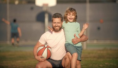 Babalar günün kutlu olsun. Aile fotoğrafı. Baba ve çocuk topu tutuyorlar. Çocuk basketbol oynuyor. çocukluk ve babalık. Koçu olan genç oyuncu. Birlikte vakit geçirin. Mutlu baba ve oğul açık havada.