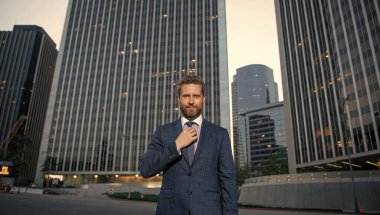 Takım elbiseli başarılı bir adam. Yönetici ofis dışında. Erkek resmi moda. Kendine güvenen sakallı patron. Formalite içinde olgun bir iş adamı. iş başarısı.