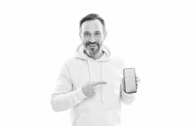 Kapüşonlu sakallı ve bıyıklı mutlu olgun bir adam akıllı telefon ekranını gösteriyor. Kopya alanını işaret ediyor..
