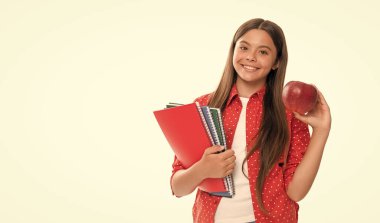 Mutlu çocuk ders çalışmak için okul defterini tutuyor ve beyaz elmalı öğle yemeği, okul yemeği..