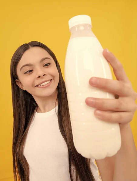 milk bottle in hand of happy child. kid hold dairy beverage product. teen girl going to drink milk. healthy lifestyle. chldhood nutrition. drinking per day. yogurt for breakfast. selective focus.