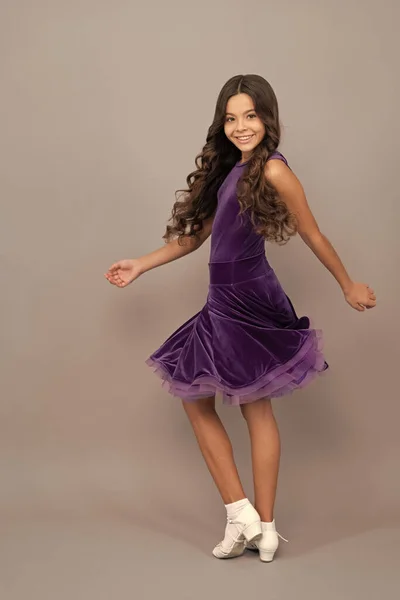 dancewear fashion clothes. happy teen girl junior ballroom dancer. child in purple dance dress. dancing school. full length of kid with curly hair. beauty and fashion. happy childhood.
