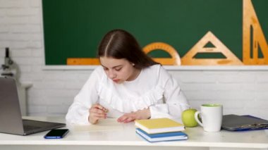 Okulda dizüstü bilgisayar kullanan ciddi kız çocuk eğitimi, e-öğrenme.