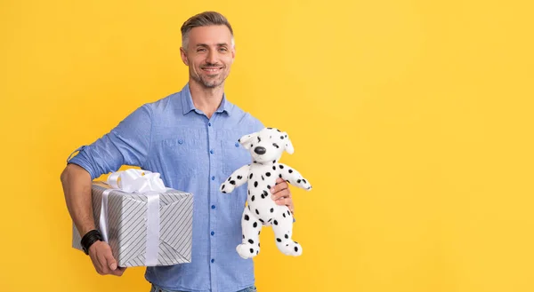 corporate present. valentines day. copy space. present for womens or mens day. man holding toy. handsome man prepare for romance date. happy guy with occasion greeting. male showing gift box.