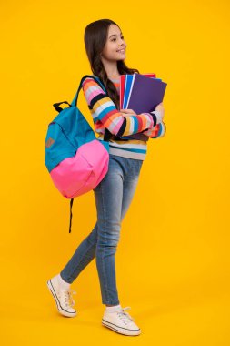 Liseli kız, genç kız, sarı izole stüdyo geçmişi üzerine kitap tutuyor. Okul ve eğitim kavramı. Okula dönelim. Mutlu ergen, pozitif ve gülümseyen genç kız duyguları