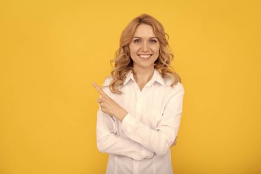 Beyaz yakalı kız. Yönetici asistanı veya çalışanı. İş kadını. Kadın patron CEO. Kopyalama alanını işaret ediyor. Beyaz gömlekli neşeli sarışın kadın. Ofis çalışanı. iş gündelik tarzı.