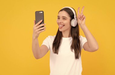 Modern eğitim çevrimiçi. İletişim teknolojisi. Akıllı telefondan kadın sohbeti. Müzik dinliyordum. Barış. Etkileyici bloglar. Kulaklıklı mutlu kız. Kablosuz kulaklıkla giyin.