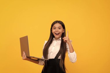 Okul üniformalı mutlu çocuk dizüstü bilgisayarda çalışıyor. Fikir ve ilhamdan ilham alıyor..