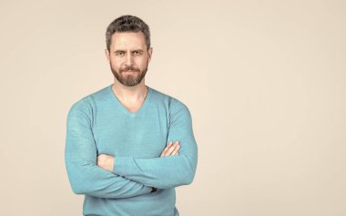 Sıradan giyinen yakışıklı adamın saçları kırlaşmış. Gri arka planda başarılı bir adam. Erkeklerin güzellik stili. Erkek modası. Tıraşsız, kıllı ve bıyıklı adam. Kendine güvenen olgun bir adam. Boşluğu kopyala.