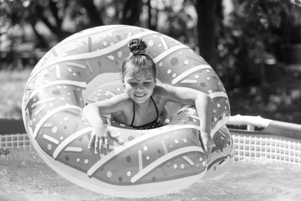 Ευτυχισμένο Παιδί Κολυμπά Πισίνα Ντόνατ Επιπλέουν Στην Πισίνα Την Ηλιόλουστη — Φωτογραφία Αρχείου