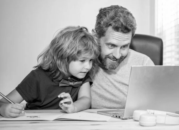 mature man teacher or dad helping kid son with school homework on computer, check email.