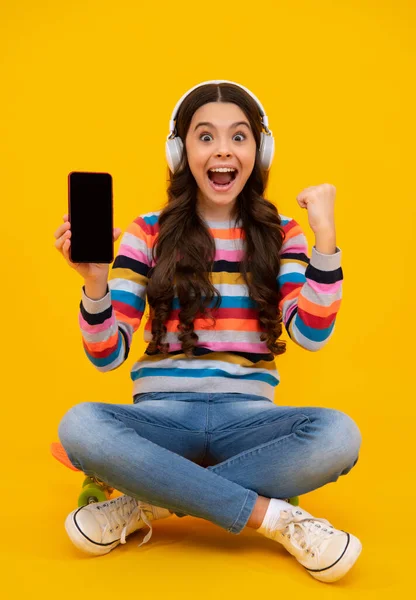 소녀들은 스마트폰을 사용하고 미디어를 공유하며 전화로 채팅을 노란색 배경에 평상복을 — 스톡 사진