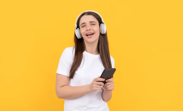 Νεαρή Κοπέλα Ακούστε Μουσική Στα Ακουστικά Κρατήστε Τηλέφωνο Κίτρινο Φόντο — Φωτογραφία Αρχείου