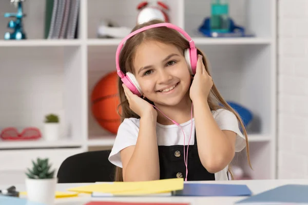 Παιδί Χαμόγελο Και Ακούσετε Μουσική Στα Ακουστικά Στην Σχολική Τάξη — Φωτογραφία Αρχείου