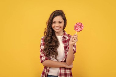 Lezzetli. Mutlu kız lolipopu tutar. Lolipop çocuk. Uzun kıvırcık saçlı hippi çocuk lolipopu tutuyor. Çubukta şeker. Karamelli şeker dükkanı. Tatlı çocukluk hayatı. Genç diş bakımı. Tatlıya düşkünüm.