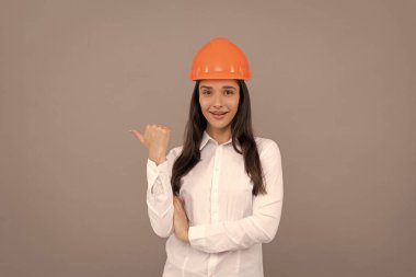 Neşeli kadın işçi baş parmağını kaldırıyor. Kaliteli müfettiş Kadın inşaat işçisi. İnşaatçı şapkalı bir iş kadını. Baş mimar mühendisi. Koruyucu miğferli girişimci. İşçi Bayramı.