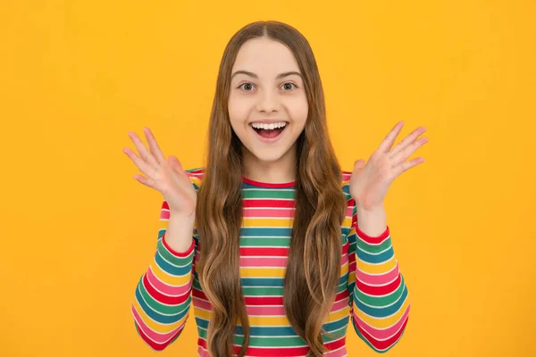 Excited kids face. Amazed expression, cheerful and glad. Amazed child with open mouth on yellow background, surprise