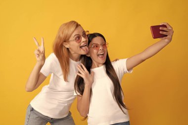 Komik anne ve çocuk akıllı telefondan özçekim yapıyor, portre.