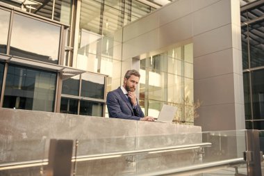 Programcı bilgisayar kullansın. Girişimci. Çevik iş. Profesyonel ağ yöneticisi bilgisayarı tutuyor. Modern kablosuz bilgisayarı olan patron. İnternette çalışan olgun bir iş adamı. iş başarısı.