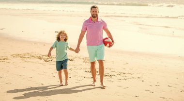 Baba oğul ve erkeğin ailesi plajda top, yaz.