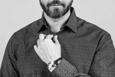 Sakallı adam, görünüm düğmesini kesti. Günlük tarz gömlek gri arka plan, resmi olmayan giyinme..